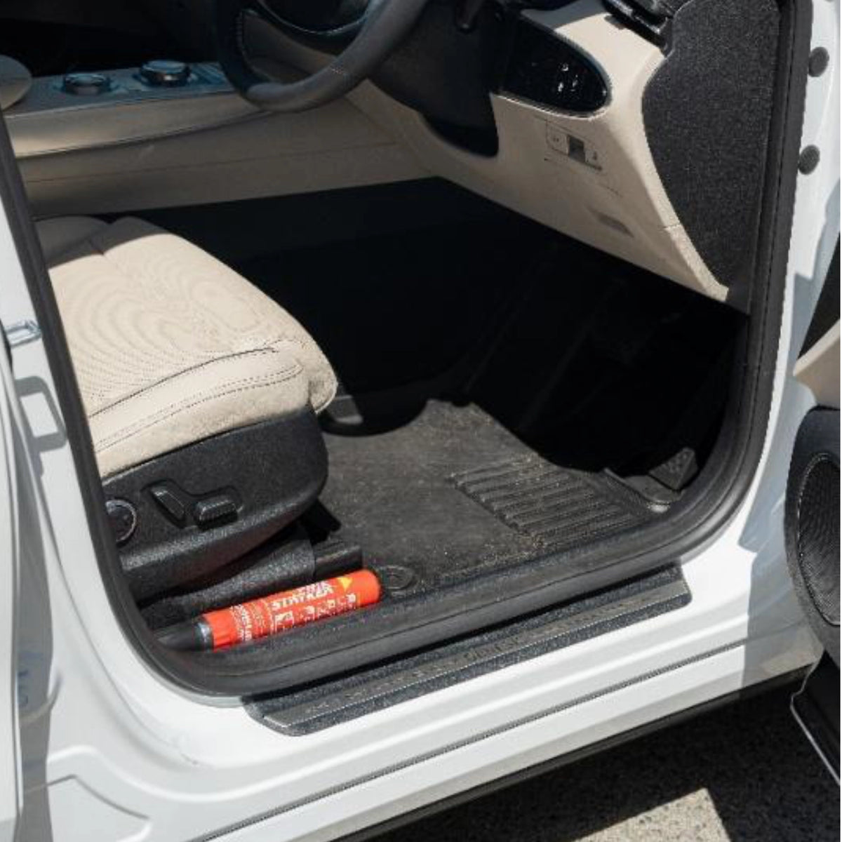FSS100 fire suppression stick stored beside the seat in a vehicle door footwell