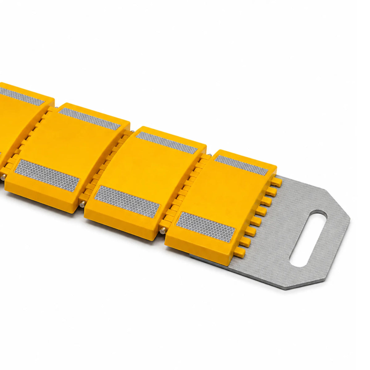 Close-up of linked yellow speed bump modules with reflective strips joining the slotted metal end plate