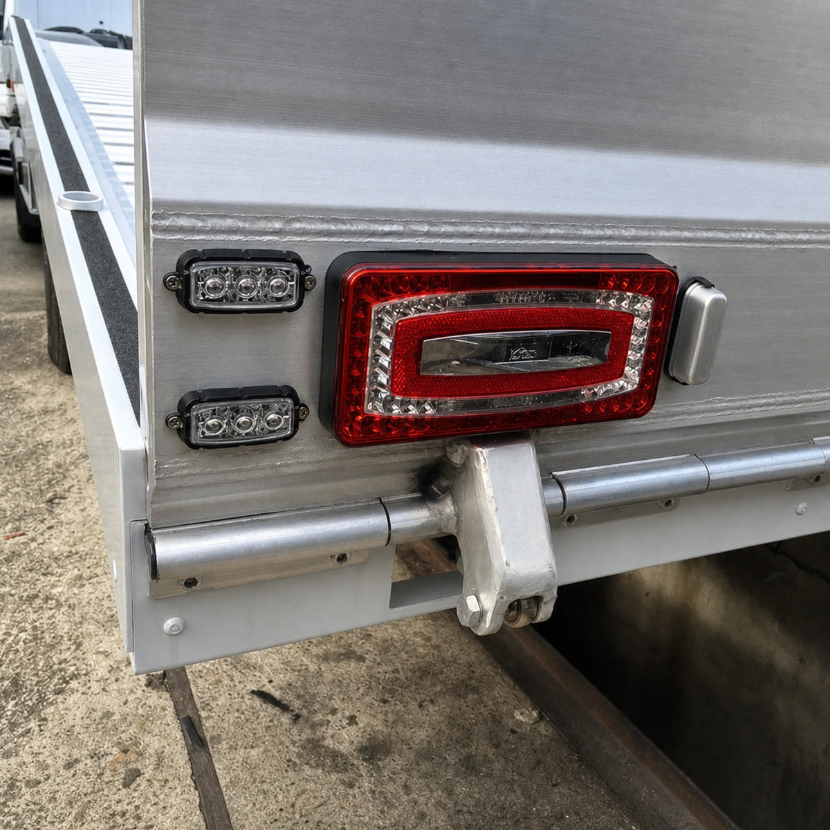 Two F3 LED warning light heads fitted in their aluminium housings and screw fixed to the rear of an aluminium truck body beside the tail light
