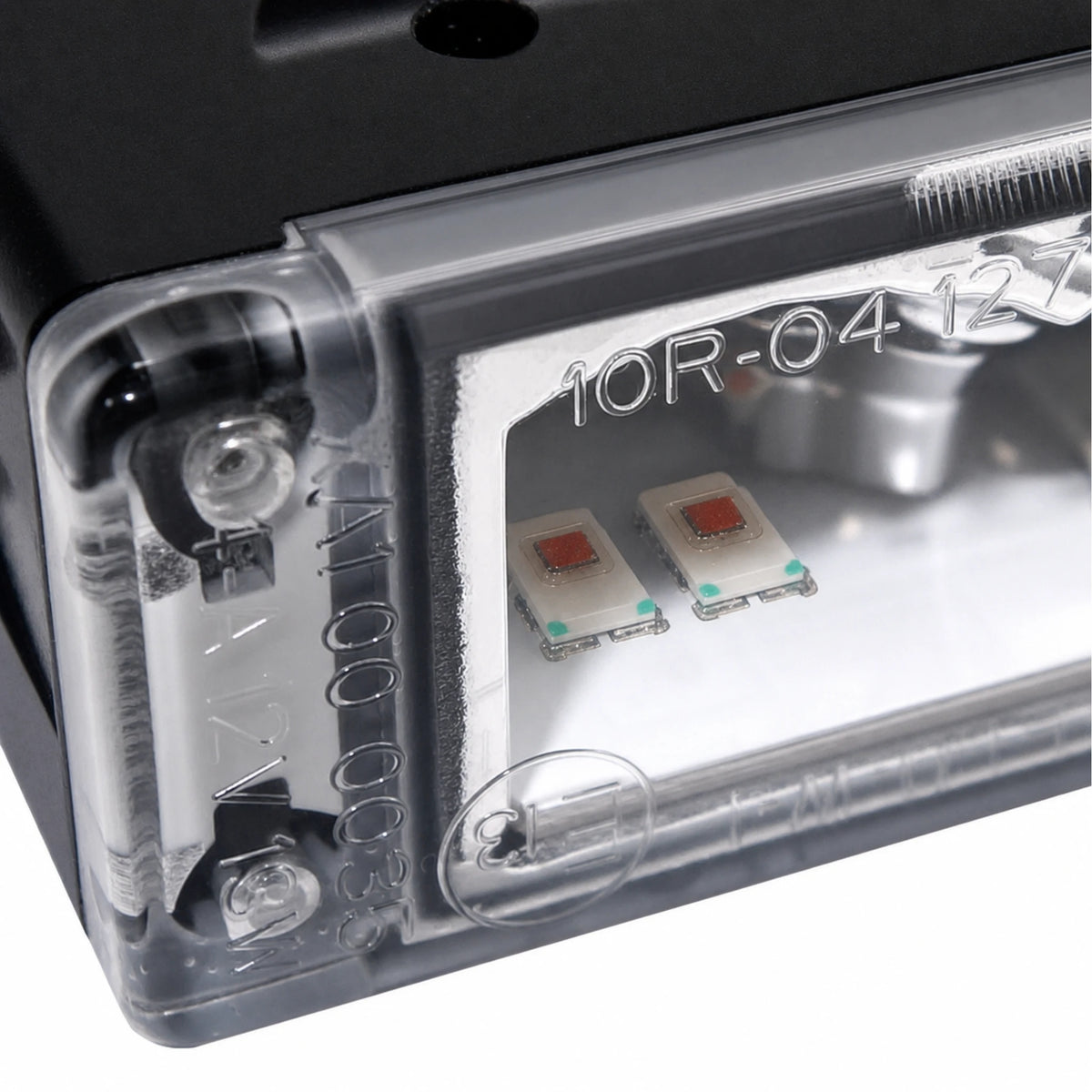 Close-up of one TC4 reflector cell showing the two LEDs sitting side by side, one for each output colour, with the ECE approval markings moulded into the lens