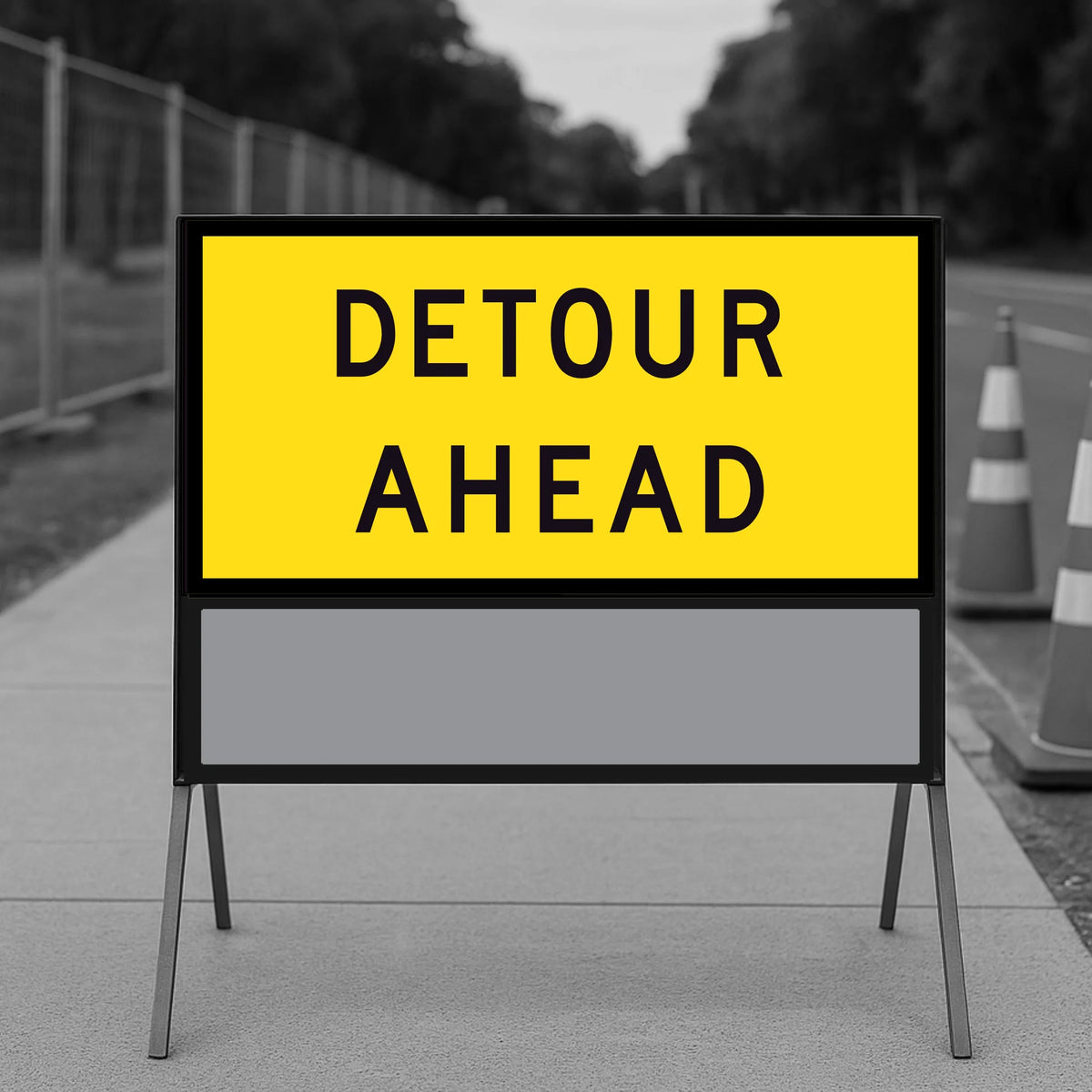 Detour Ahead TM1-6C 1200x600mm corflute panel filling the upper position of a multi-message sign frame with a blank panel below, on a footpath with traffic cones and temporary fencing