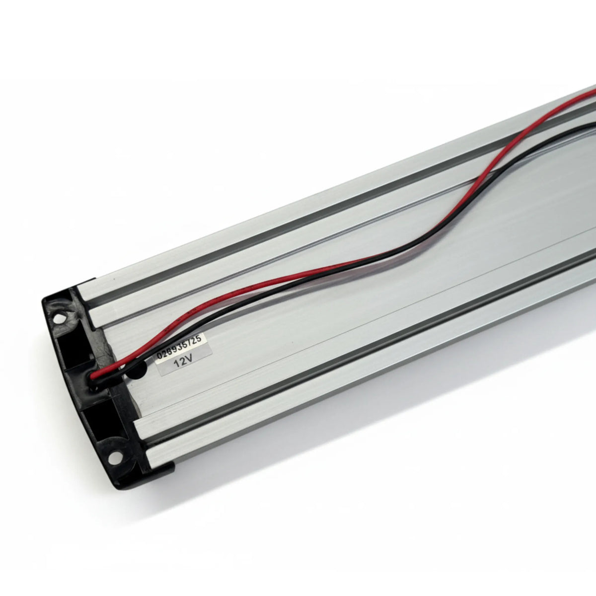 Back of the LED strip light showing the aluminium extrusion, 12V label and red and black wiring