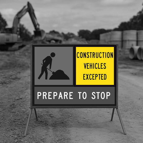 Construction sign warning of stopped traffic except for construction vehicles, with a blurred background of a construction site.