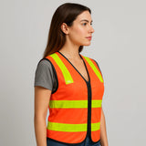 Woman wearing an orange safety vest with reflective yellow stripes on a gray background