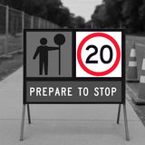 temporary traffic sign indicating a speed limit of 20 and a pedestrian crossing ahead, on a road with traffic cones.