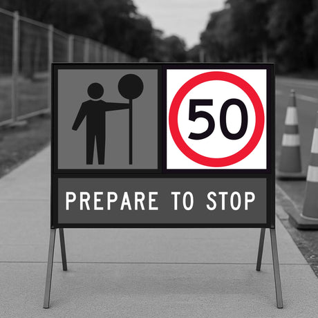 Road sign indicating a speed limit of 50 with a pedestrian symbol, on a road with traffic cones.