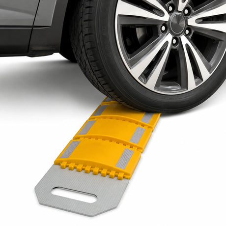 Vehicle tyre crossing the yellow rollout speed bump laid across the road surface