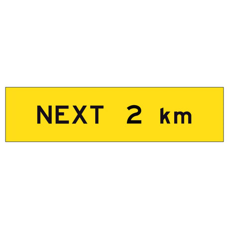 “NEXT 2 km” TM1-28B black text on retroreflective yellow – 1200x300mm corflute sign panel.
