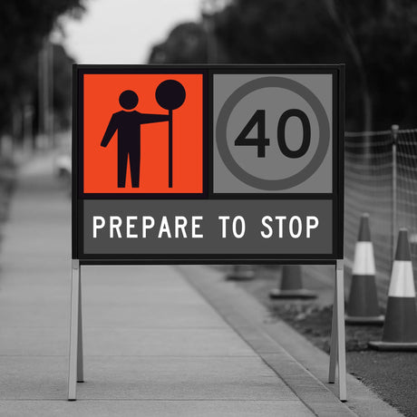 Road sign warning of a stop ahead with traffic cones in the background