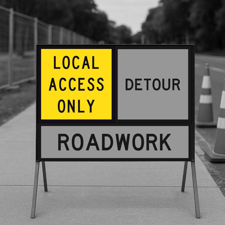Roadwork sign indicating 'Local Access Only' and 'Detour' with a blurred background of road and cones.