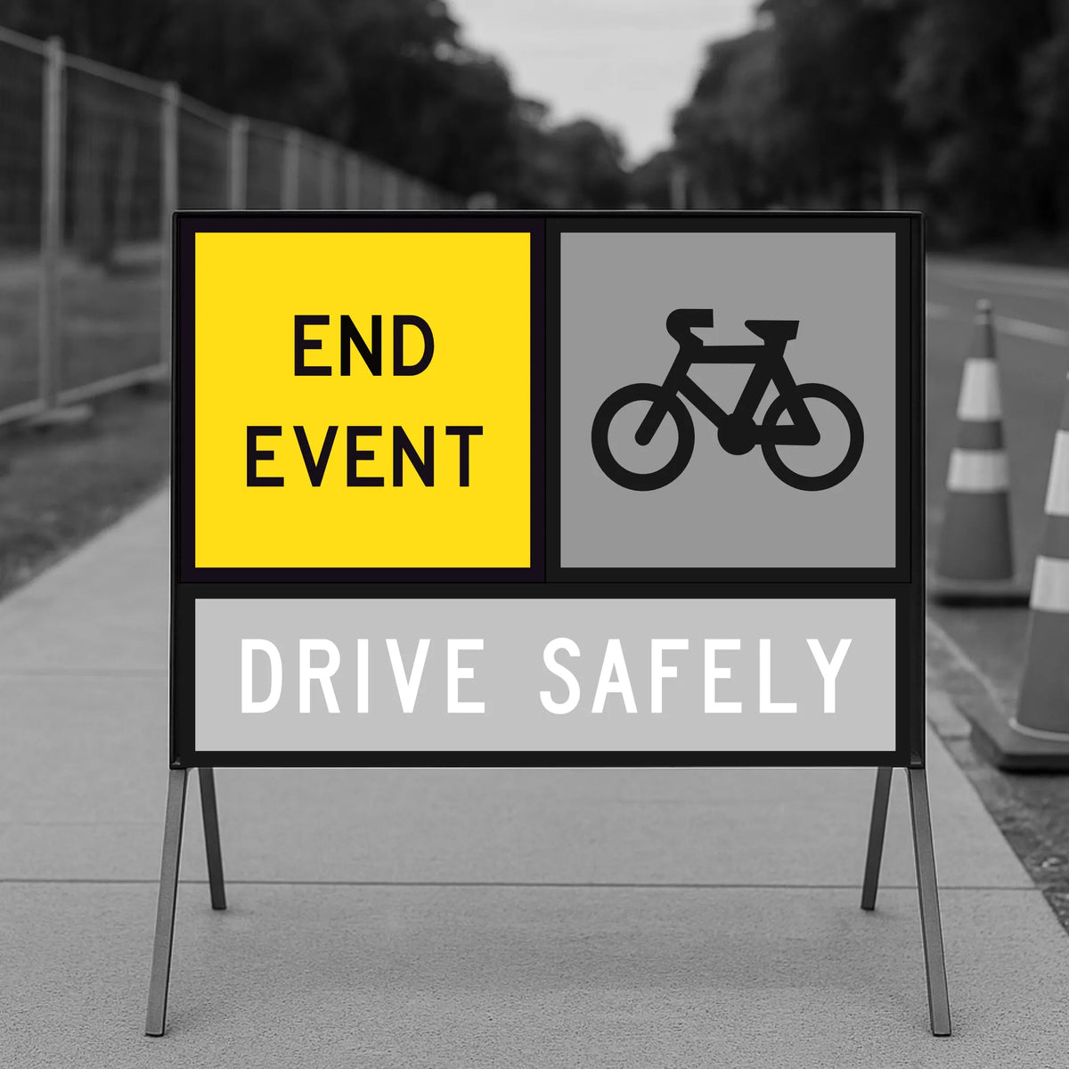 Road safety sign with 'End Event', 'Drive Safely', and bicycle icon on a blurred road background.