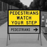 Warning sign for pedestrians to watch their step on a sidewalk.