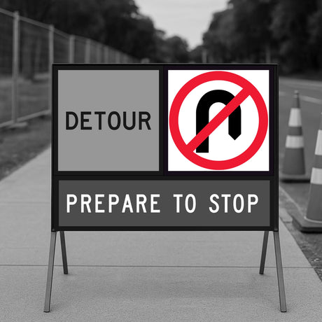 Road sign indicating a detour with a no U-turn symbol on a blurred background.