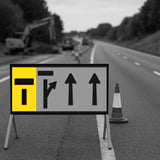 Roadwork sign with arrows on a blurred road background