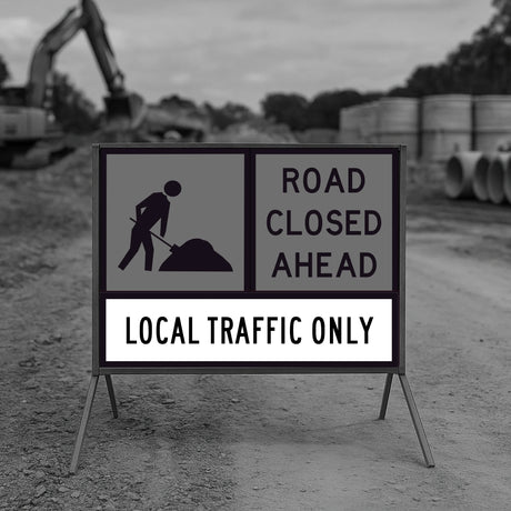 traffic control road closed ahead sign with construction equipment in the background