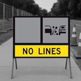 No Lines 1200x300mm corflute panel in the lower slot of a multi-message sign frame below a blank yellow panel and a Loose Stones symbol panel, on a footpath with traffic cones and temporary fencing