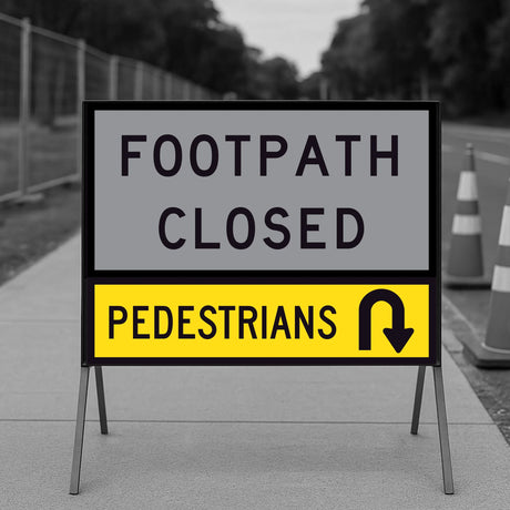 Pedestrians U-Turn corflute panel in the lower slot of a multi-message sign frame below a FOOTPATH CLOSED panel, on a footpath with traffic cones and temporary fencing