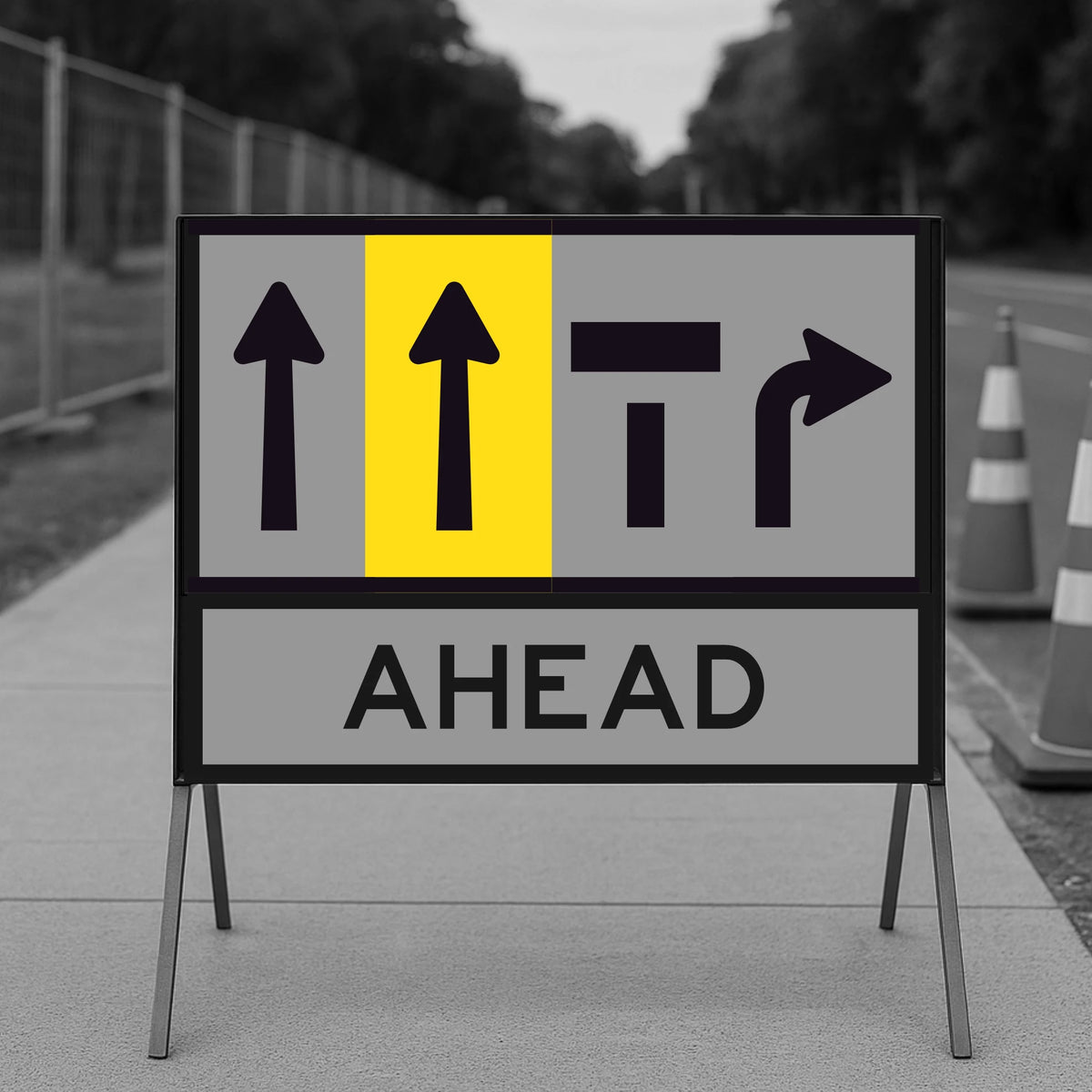 Temporary traffic control road construction sign with lane status arrows and 'AHEAD' text on a blurred background