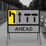lane status road sign with directional arrows and 'AHEAD' text on a blurred background