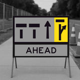 Temporary traffic control lane status road sign with directional arrows and 'AHEAD' text on a stand outdoors.