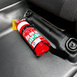 Red fire extinguisher held in its own wire strap bracket, bolted to a black seat mount bracket on the passenger seat rail of an N80 Toyota Hilux
