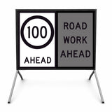 Temporary traffic road sign with speed limit 50 ahead and road work ahead warning on a stand.