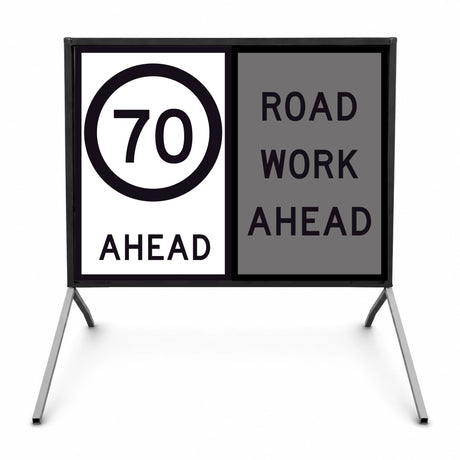 Temporary traffic road sign with speed limit 70 ahead and 'Road Work Ahead' message on a stand.