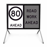 Temporary traffic control road sign with speed limit 80 ahead and 'Road Work Ahead' message on a stand.