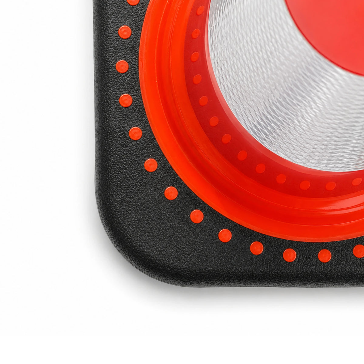 Top-down corner view of the black cone base with orange interlock studs around the reflective collar