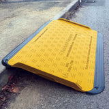 SupaGrip SafeKerb ramp positioned over a kerb seen from the road, showing the moulded surface text and ribbed LowPro edges