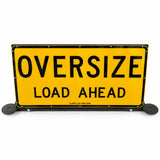 Oversize Load Ahead pilot vehicle sign raised upright on its black steel frame, with beacon plates fitted either side