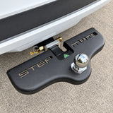 Black Stepmate towbar step fitted under the tow ball on the rear of a white vehicle