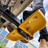 Person standing on a yellow Stepmate towbar step fitted to a tow bar, viewed from below