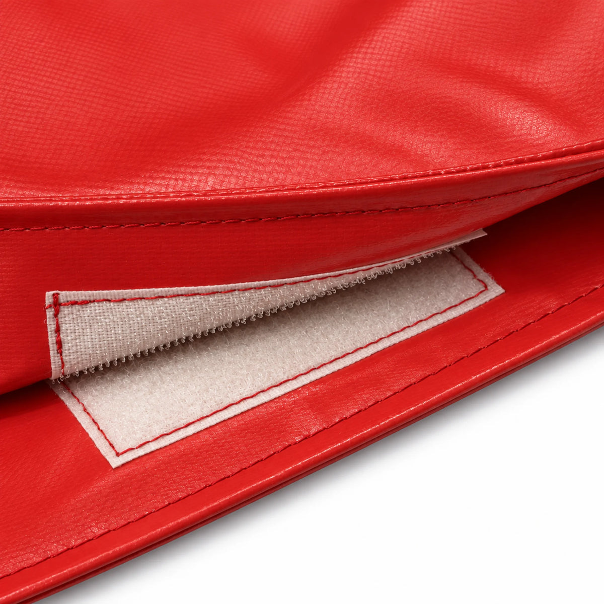 Close-up of a hook-and-loop closure tab on the red stop slow bat cover