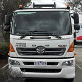White Hino 500 truck with amber warning beacons fitted at the top of the cab, photographed from the front