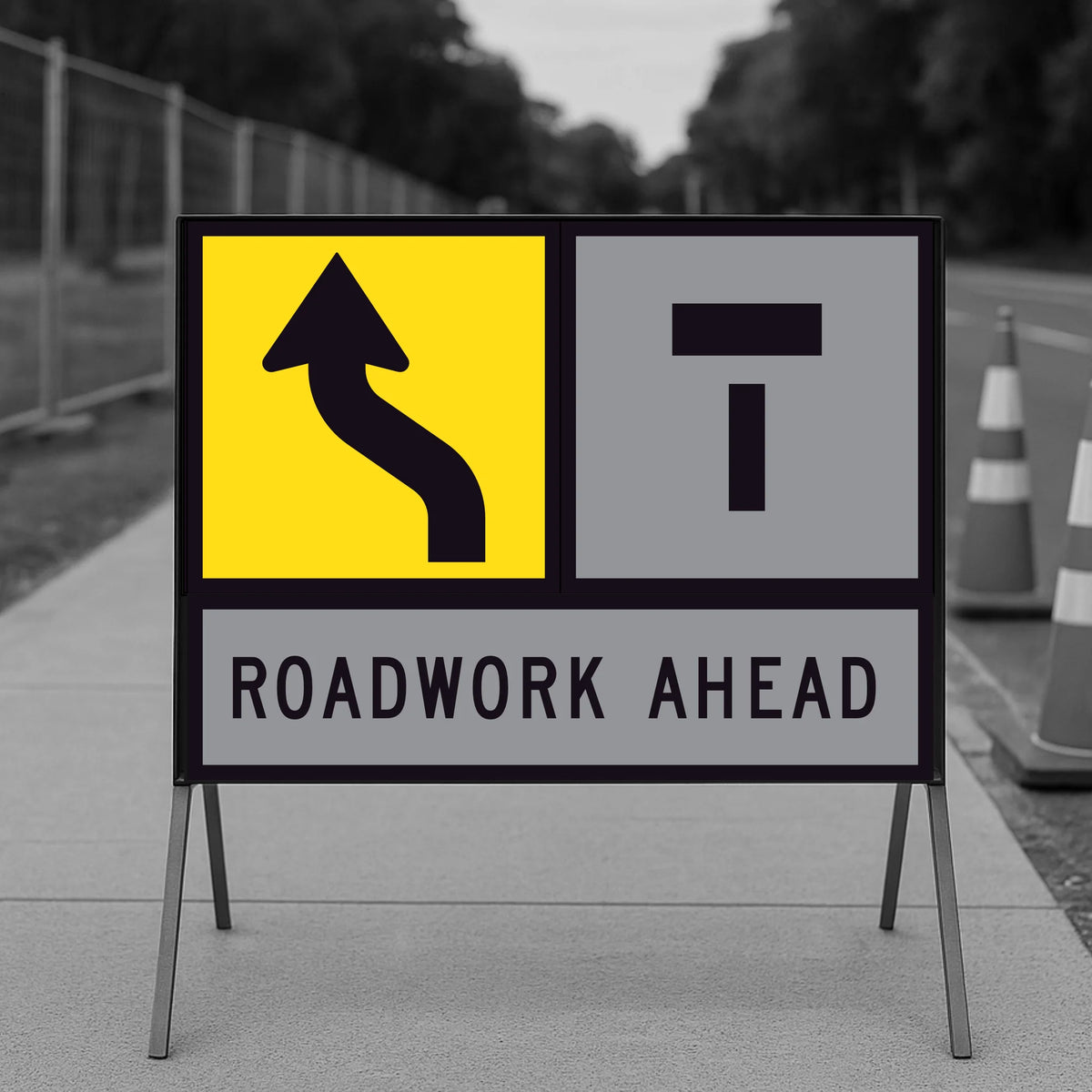 Lane Shifts Left TM10-15A corflute panel in a multi-message sign frame with the shift arrow in the left-hand position and a Lane Closed Ahead T symbol in the right-hand position, reading as the left lane shifting left with the right lane closed ahead, and a ROADWORK AHEAD panel below, on a footpath with traffic cones and temporary fencing
