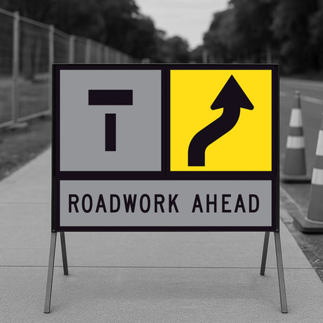 Lane Shifts Right TM10-16A corflute panel in a multi-message sign frame with a Lane Closed Ahead T symbol in the left-hand position and the shift arrow in the right-hand position, reading as the left lane closed ahead with the right lane shifting right, and a ROADWORK AHEAD panel below, on a footpath with traffic cones and temporary fencing