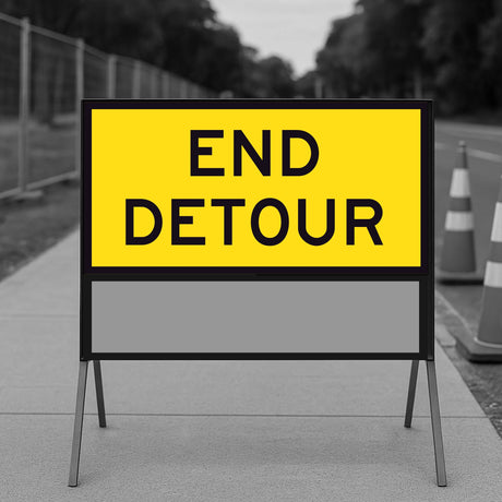 Yellow 'END DETOUR' sign on a stand with a blurred background