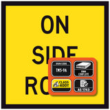 Yellow sign ON SIDE ROAD with black text and an orange rectangular label on a yellow background