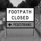 Footpath closed sign with an arrow pointing left on a sidewalk.