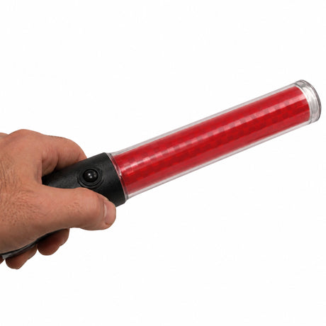 Hand holding an illuminated red LED traffic marshalling wand, showing the LED dot pattern through the tube